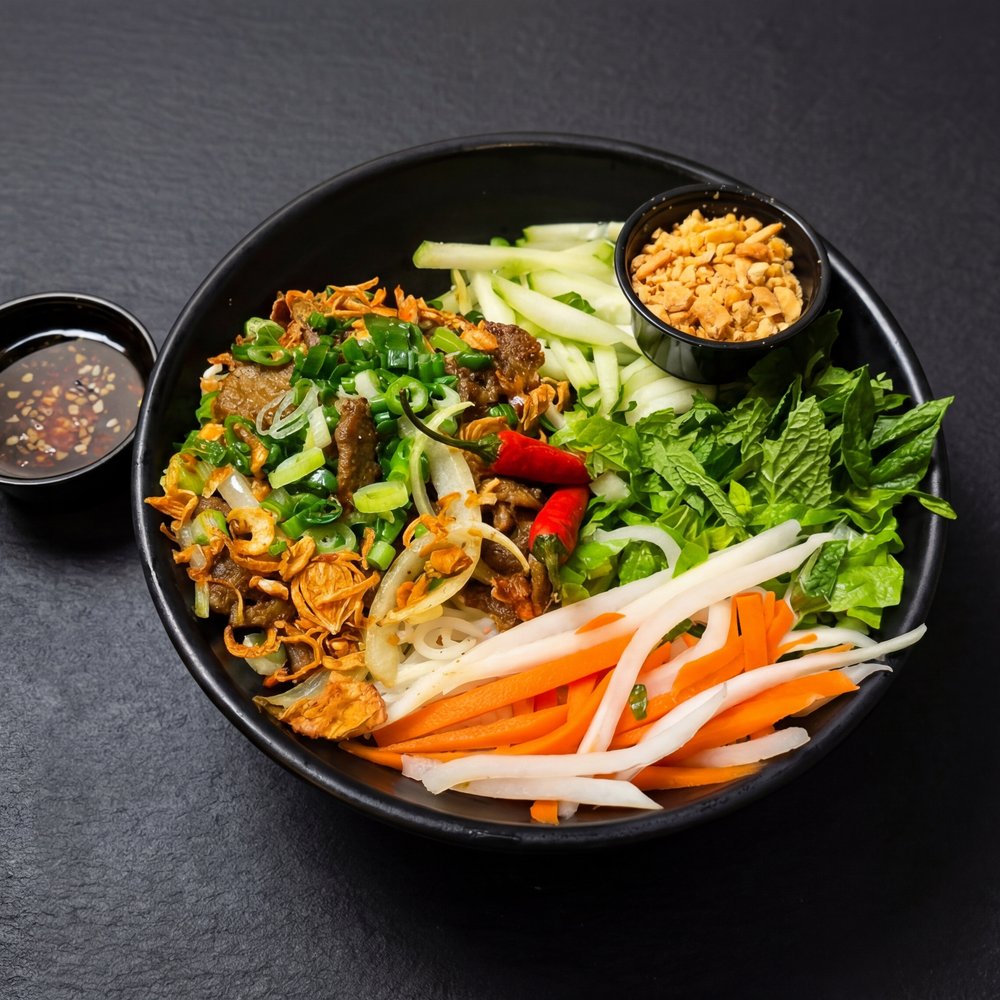 Bún Thịt Nướng — vermicelli noodles with grilled pork, herbs, peanuts, and pickled vegetables
